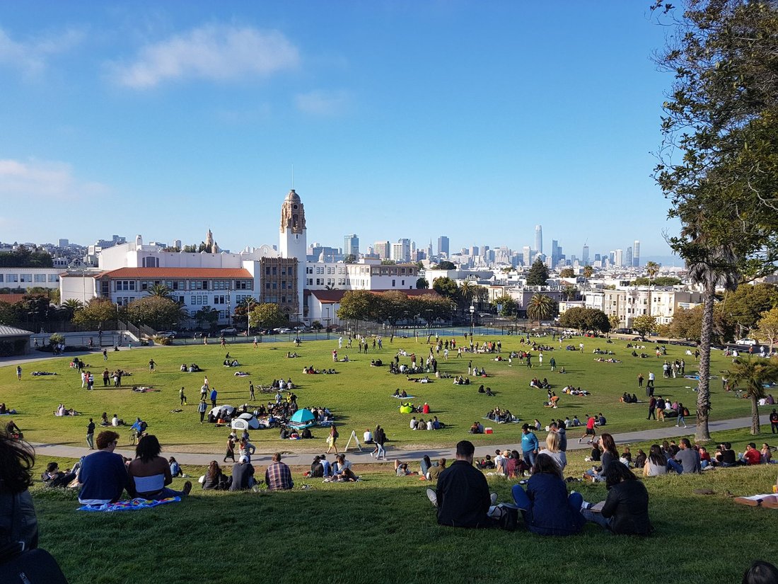 sunny afternoon in Dolores Park with downtown San Francisco skyline in background