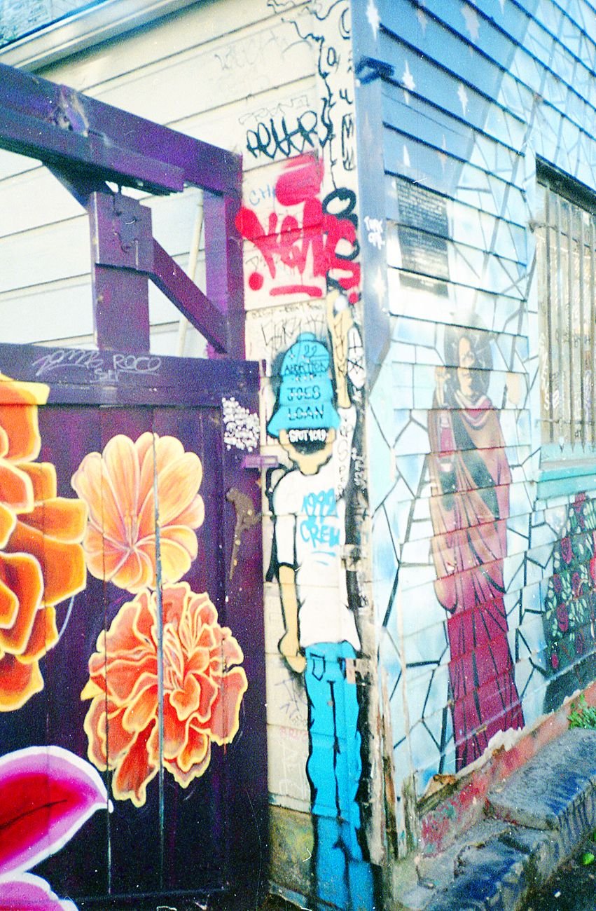 Bold political and abstract murals covering the walls of Clarion Alley